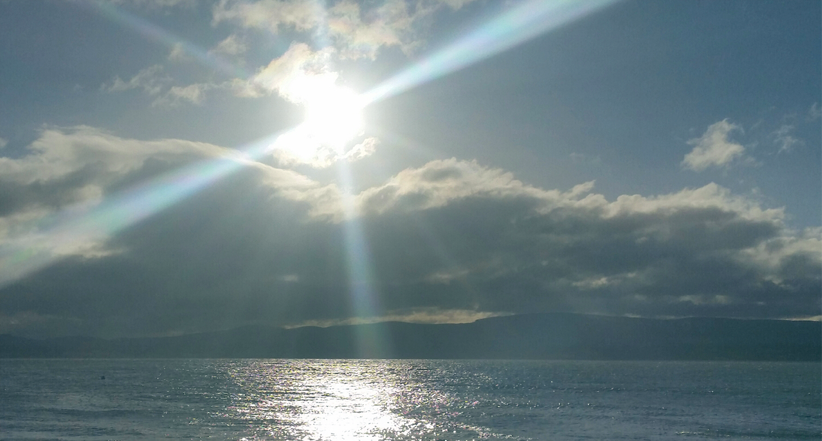 Light shining across a calm landscape